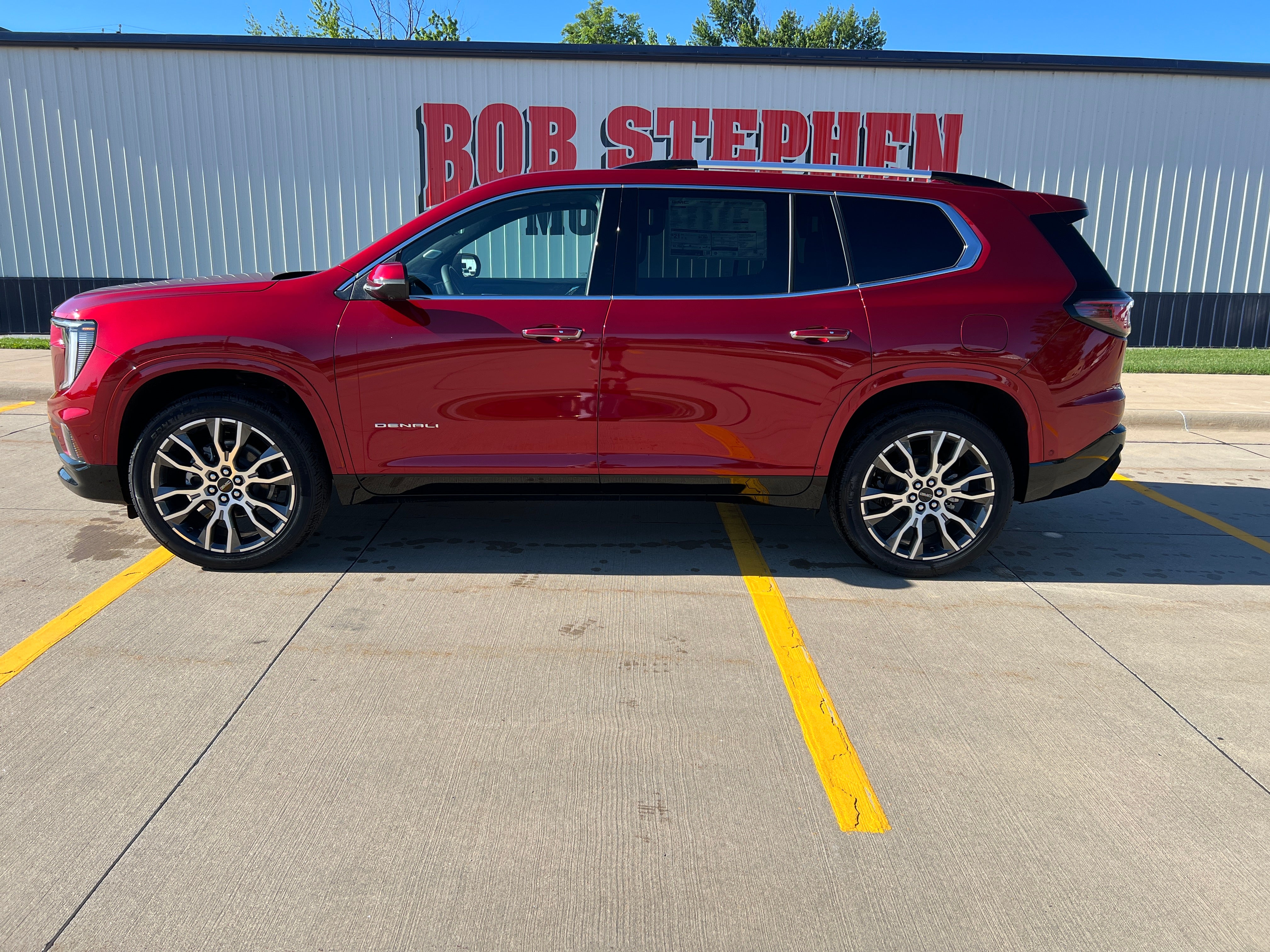 2026 GMC Acadia Denali Ultimate in Volcanic Red Tintcoat — front three-quarter view